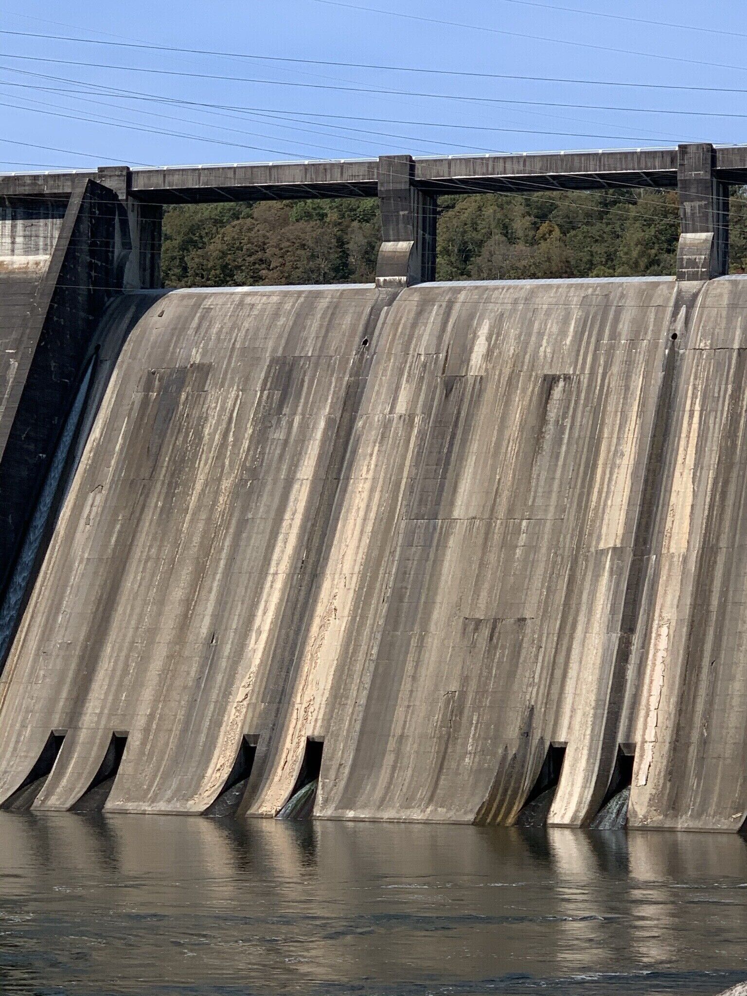 Een betonnen dam met stromend water.