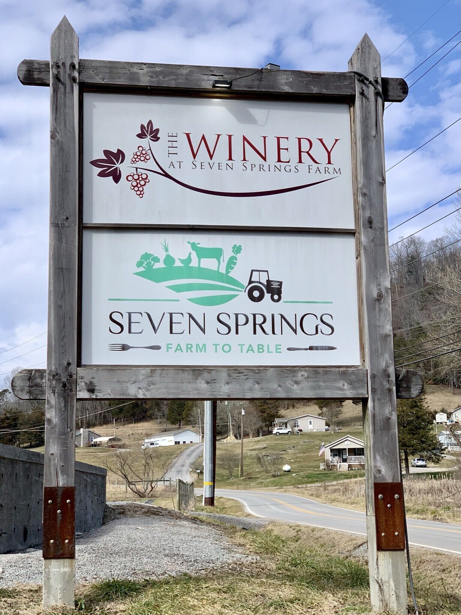 Schild für ein Weingut und ein Restaurant mit regionalen Produkten.