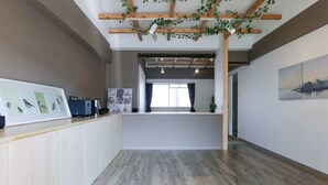 A reception area with a wooden counter, framed pictures, and a cityscape painting. - Tarbo's House TDS Recently Renovated (Nara)