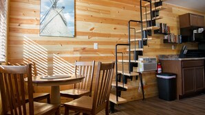 Un interior de madera con comedor, escalera y cocina.