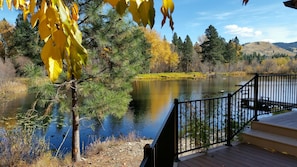 A wooden deck overlooking a calm lake with surrounding trees and hills. - Trout Farm ponds, wildlife corridor on creek and river - a perfect getaway (Hamilton)