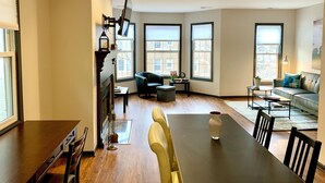 Un salón amplio con comedor, ventanas grandes y chimenea.