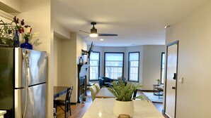 Una cocina moderna con una isla central, electrodomésticos de acero inoxidable y ventanas amplias.
