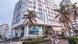 A tall, modern building with a unique architectural design, featuring a prominent vertical element and multiple balconies. - Spacious & Luxury apt in Bocagrande in Palmetto Beach (Cartagena)