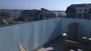 Un balcon avec vue sur la mer, une chaise en bois et une table.