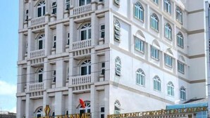 Un hotel de varios pisos con un estilo arquitectónico clásico, con balcones y ventanas amplias.