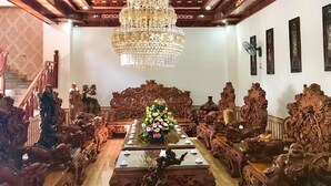 Una habitación con elaboradas tallas de madera, un candelabro y un centro de mesa floral.