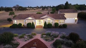 A two-story house with a front porch, a garage, and a landscaped front yard with various plants and a pathway. - Tranquil Acres, Relaxing Wine Country Retreat with Game Room (Santa Rosa)
