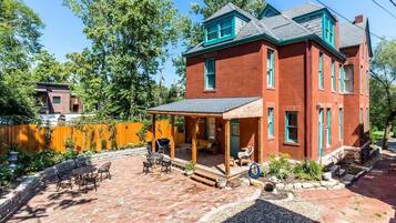 A red brick house with a covered patio and outdoor seating area.
