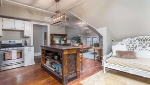 Amplio loft con cocina, comedor y una cama grande con cabecera decorada.