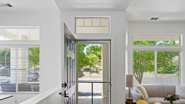 Un salon moderne doté d’une porte-fenêtre coulissante donnant sur un patio.