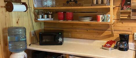 A compact kitchen with a microwave, coffee maker, and a small refrigerator.