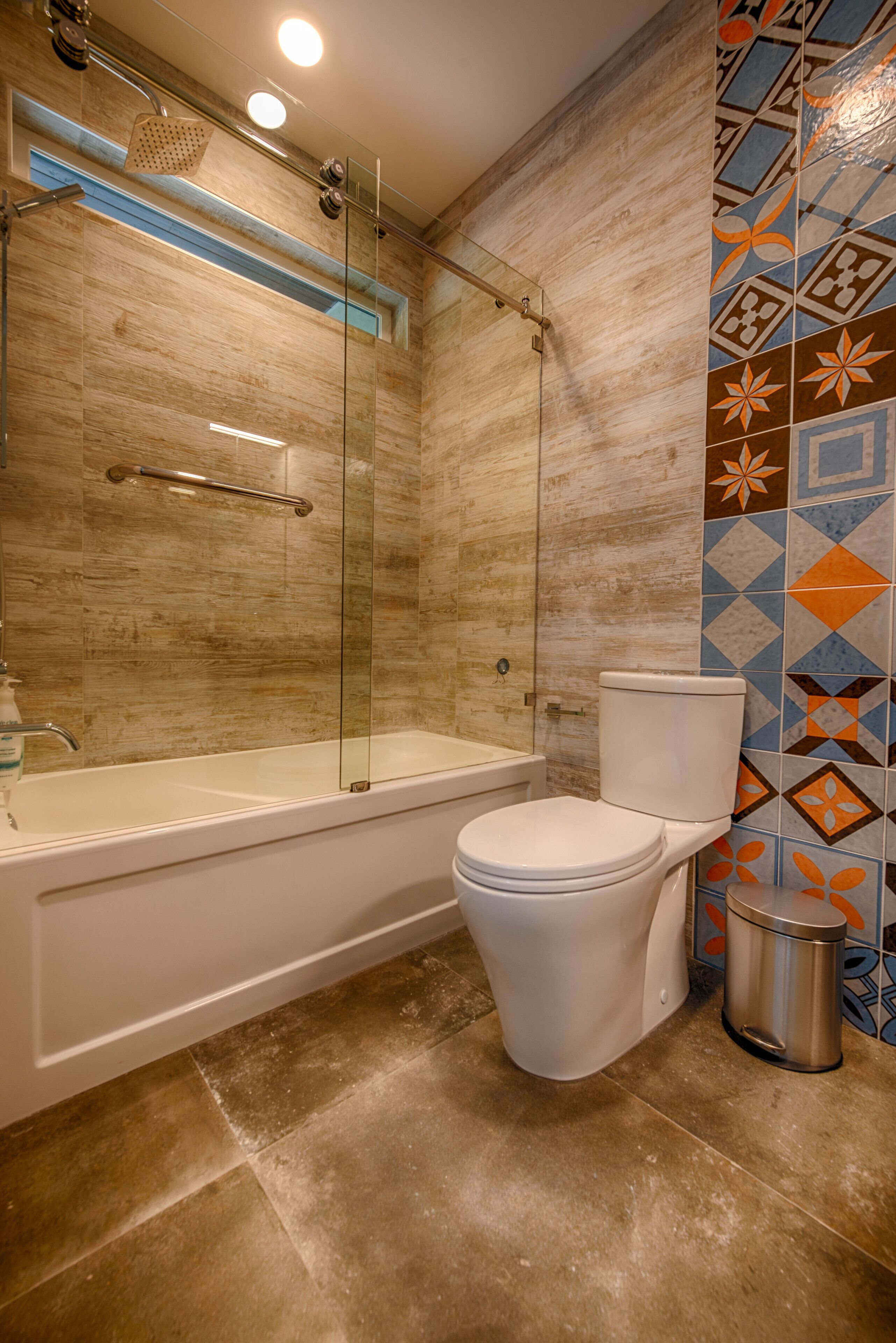 Een moderne badkamer met een douchekabinet van glas, een wit bad en een toilet.