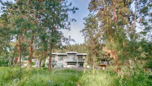 A modern two-story building surrounded by dense forest. - Modern 3 bedroom, 3 en suites, dog friendly loft in McKinley (Kelowna)
