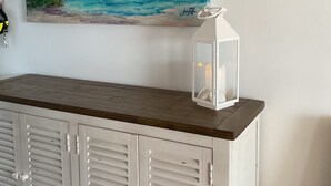 A white cabinet with louvered doors, a painting of a beach scene, and a white lantern on top. - Incredible Waterfront View, Pool, Dolphins, Fishing, Docks, Snook Inn 1 block up (Marco Island)