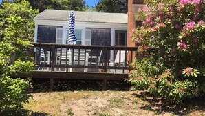 A house with a wooden deck, a brick chimney, and a garden with pink flowers. - Old Cape Cod Charm in Chatham MA, 1/4 mile Walking Distance to Hardings Beach (Chatham)