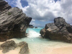 A rocky beach with clear turquoise water and a cloudy sky. - [A]MOUR AMOUR 

Lighthouse Views • Walk to Beaches • Classic Bermuda Charm (Hamilton)