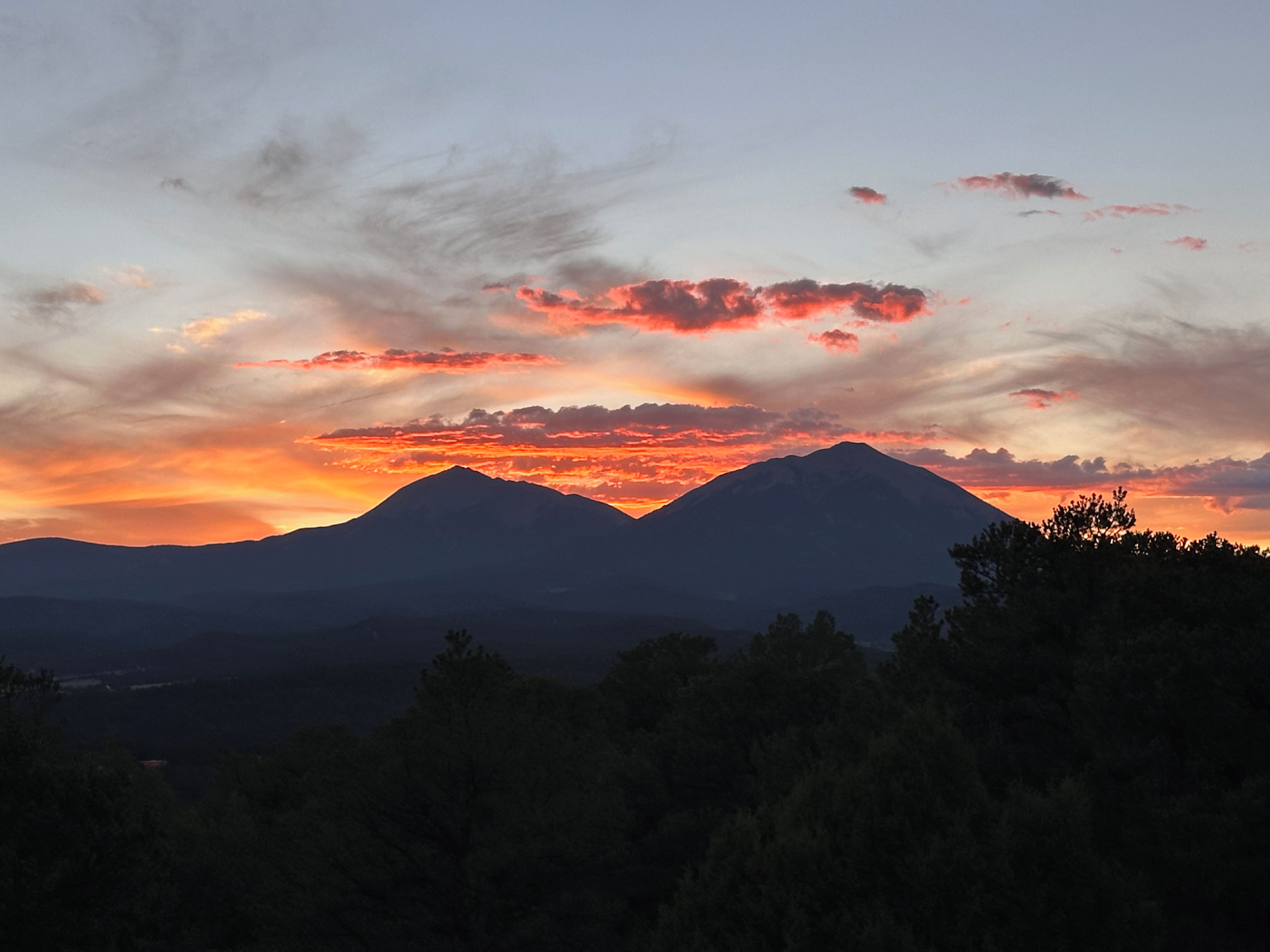 A mountain range silhouette against a sunset sky.