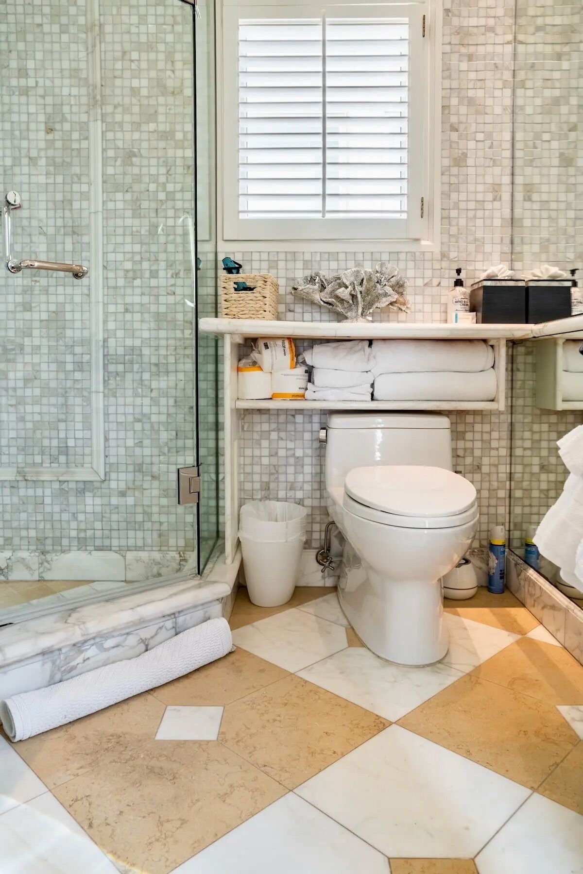 A bathroom with a toilet, shower, and tiled floor.
