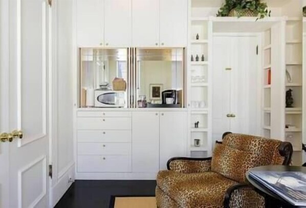 A compact room with white cabinetry, a leopard print chair, and a small table. - Chic Victorian Studio Pacific Heights (SF)