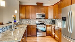 A modern kitchen with wooden cabinets, stainless steel appliances, and a granite countertop. - 60 Minutes to Ski Country, 15 Minutes to Downtown Denver (Golden)