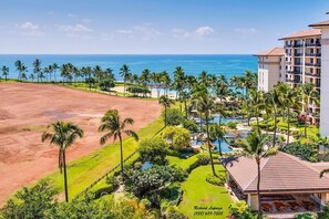 A resort with a pool, palm trees, and a view of the ocean. - Beachfront Beach Villas at Ko Olina O-501 (Kapolei)