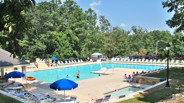 A pool area with lounge chairs and umbrellas, surrounded by trees. - 🌄Resort Vacations at Fairfield Glade TN Spacious two bedroom Golf Villa (Fairfield Glade)