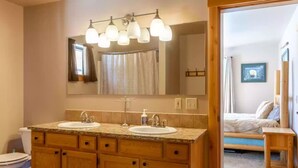 A bathroom with two sinks, a large mirror, and a shower curtain. - The perfect place for outdoor recreation (Thayne)