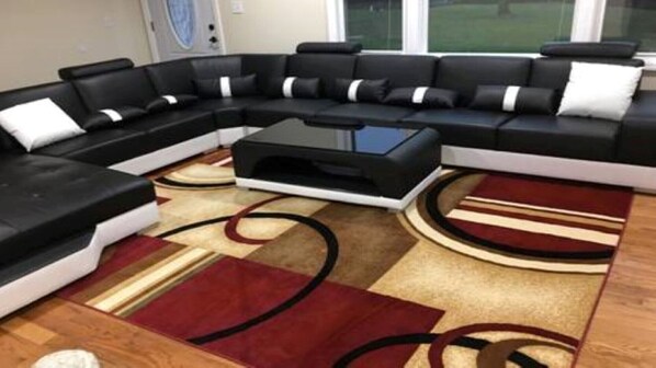Relax in this stylish living room with a comfortable sectional sofa, coffee table, and patterned rug.