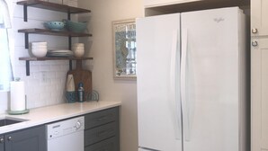 A kitchen with white cabinets, a white refrigerator, and a dishwasher.