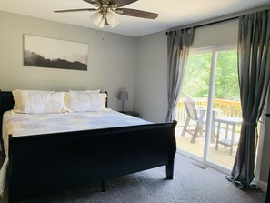 A bedroom with a bed, a ceiling fan, a window with curtains, and a view of a deck. - Norris Nook: Lakefront 9br/11ba, Private Dock,Private HotTub,Sleeps 32, Gameroom (LaFollette)
