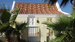 A building with a tiled roof, a white door, and a sign reading "WESTPUNT13". - Superior 1-Bedroom Apartment - Aruba Cunucu Residence (Oranjestad)