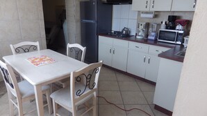 A compact kitchen with white cabinets, a refrigerator, a microwave, and a coffee maker. - Superior 1-Bedroom Apartment - Aruba Cunucu Residence (Oranjestad)