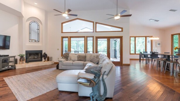 Una amplia sala de estar con un sofá modular grande, una chimenea y un comedor con mesa y sillas.