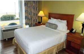 Relax in this inviting space with a large bed, two bedside tables, and a window with curtains.