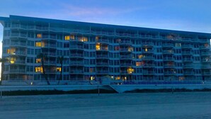 Un hotel de varios pisos con balcones, vista al agua y un puente que conduce al edificio.