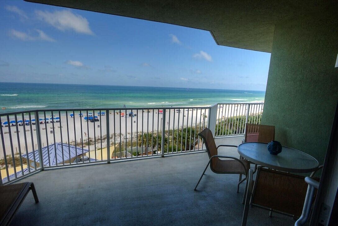 Ein Balkon mit Blick auf Strand und Meer.