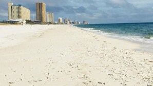 Een strand met een rij hoge gebouwen op de achtergrond.