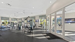 A modern gym with various exercise equipment, large windows, and a view of the outdoors. - D-Gated Resort-5 miles to Disney-2 FREE Water Park (Osceola County)