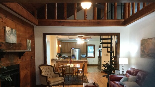 A spacious living room with a fireplace, a dining area, and a kitchen in the background. - Outrageous! Near Microsoft Mt Pleasant - Sleeps 18 (Kenosha)