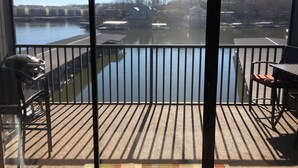Ein Balkon mit Seeblick, einem Grill und einem Tisch.