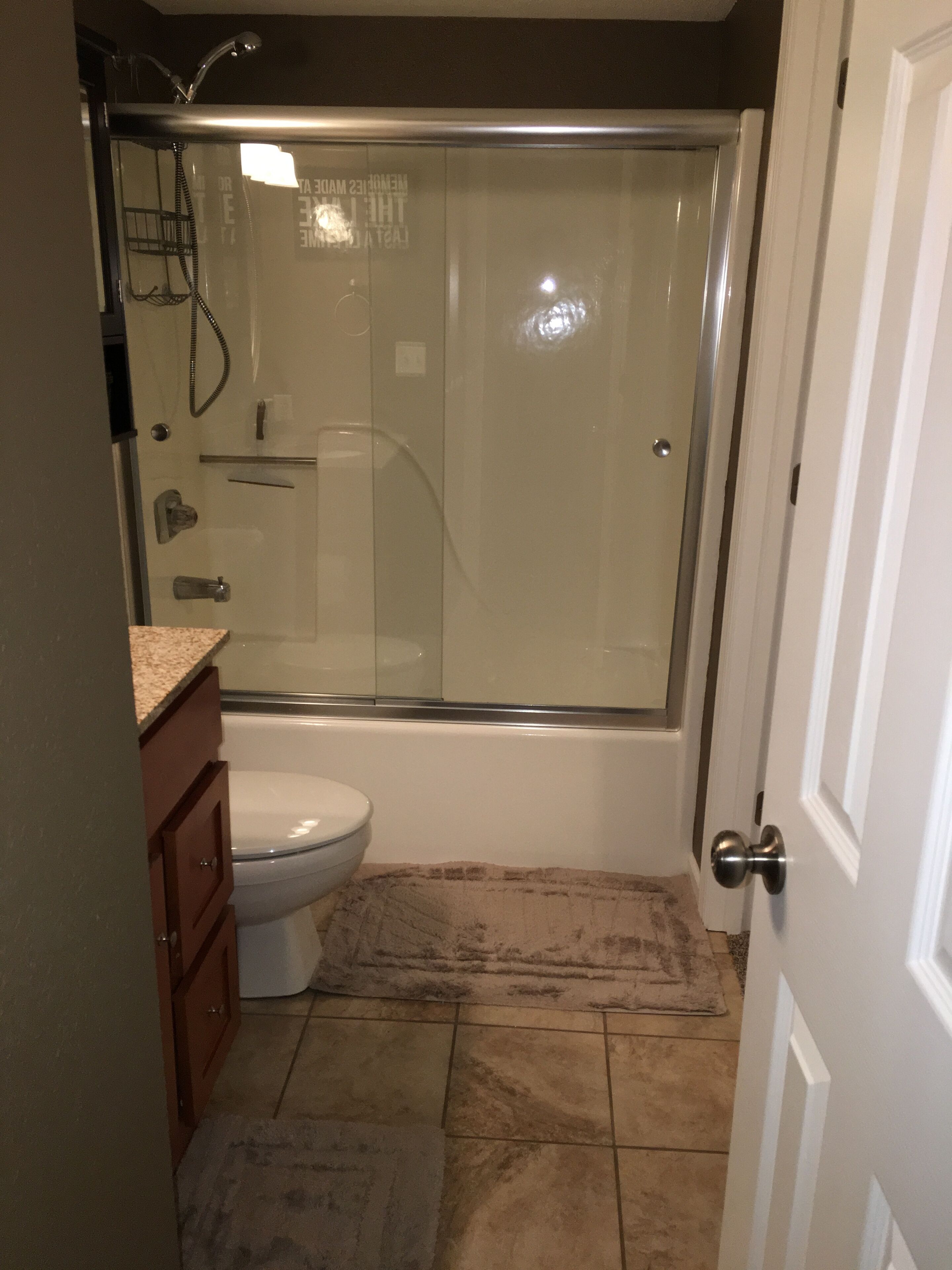Une salle de bain avec une douche à parois de verre, des toilettes et un lavabo avec un meuble-vasque.