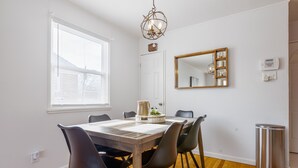 A dining area with a wooden table, black chairs, a chandelier, a mirror, and a trash can. -  Pretty  *3BDR/2Bath Home* in a Good Area Next to Parks & Close to Downtown! (St. Louis)