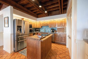 A kitchen with wooden cabinets, stainless steel appliances, and a tiled backsplash.