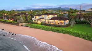 A beachfront property with multiple houses, a sandy beach, and lush greenery. - Hale Ohe | Historic Beachfront Home with A/C + Baby Beach (Koloa)