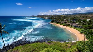 A coastal view with a beach, ocean waves, and a residential area with houses and a hotel. - Hale Ohe | Historic Beachfront Home with A/C + Baby Beach (Koloa)