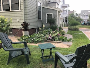 Una proprietà residenziale con un giardino antistante, un piccolo giardino e due zone relax all'aperto.