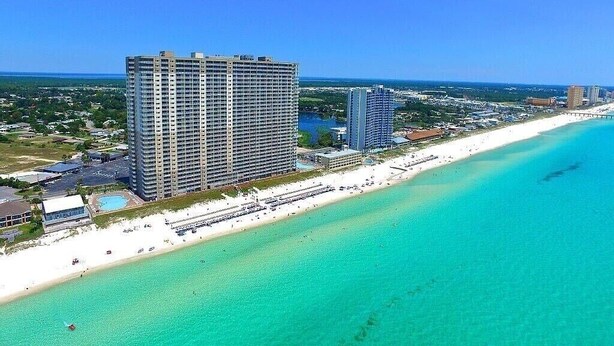 A coastal hotel with a beach view, multiple high-rise buildings, and a clear blue sea. - Royal Beachfront Unit, Sleeps 6, Walk to Pier Park (Panama City Beach)