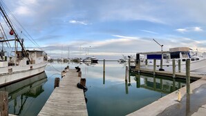Una marina con barcos amarrados a muelles de madera, agua tranquila y cielo despejado.
