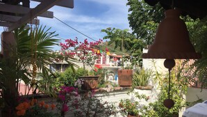 A courtyard with potted plants and a hanging bell. - Bed and breakfast Bugambilias  (Puerto Vallarta)